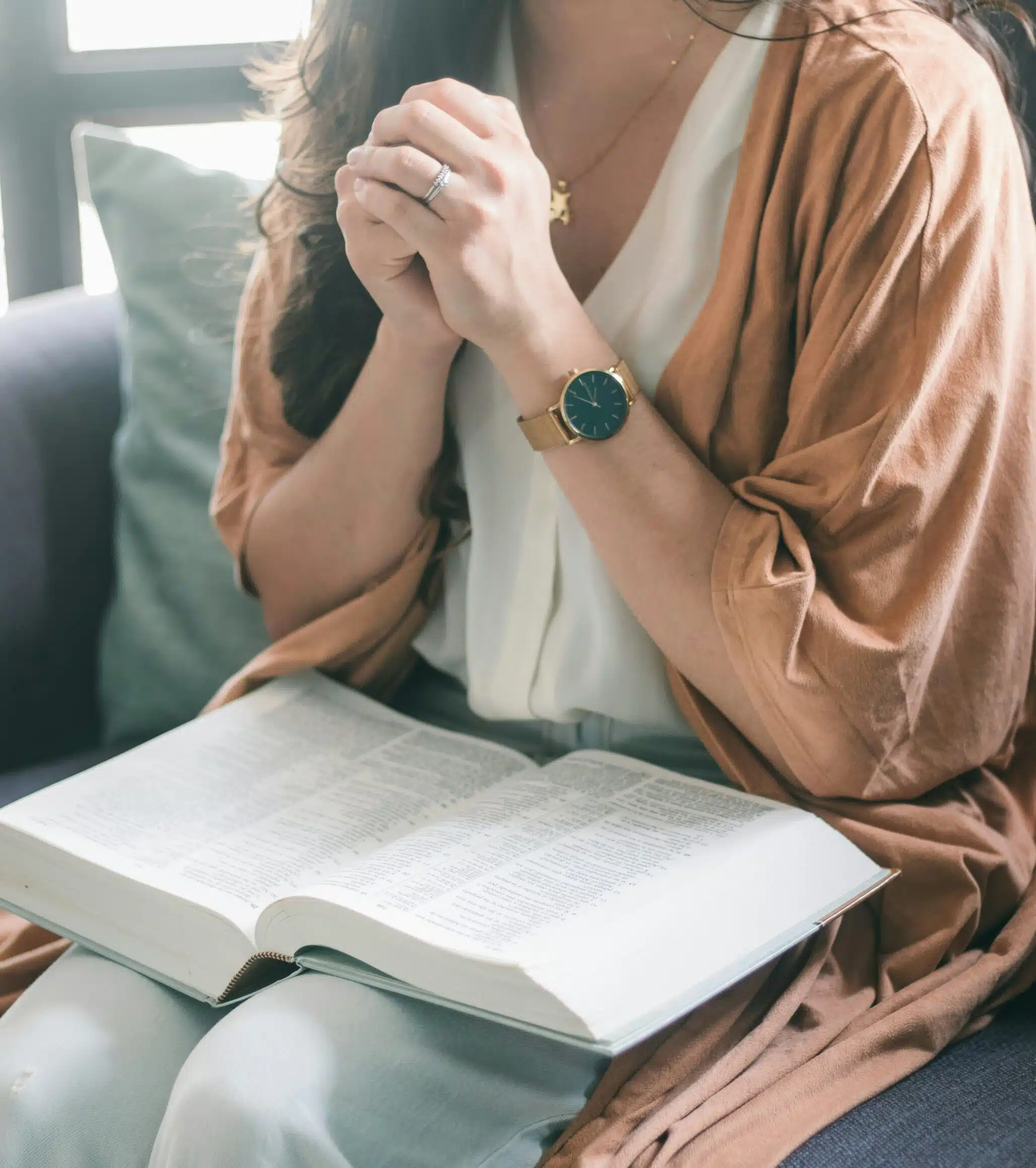 Woman reading with hands folded
